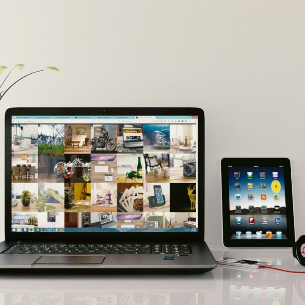 An open laptop, a tablet and a mobile phone.