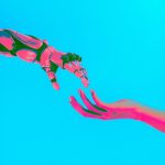 a robot arm and human arm reach out to touch