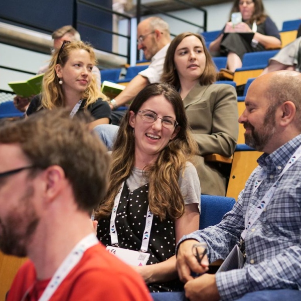 A group of people sitting in rows in an auditorium.