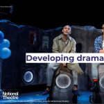 A man sits on a washing machine looking up. The words Developing drama cross the screen